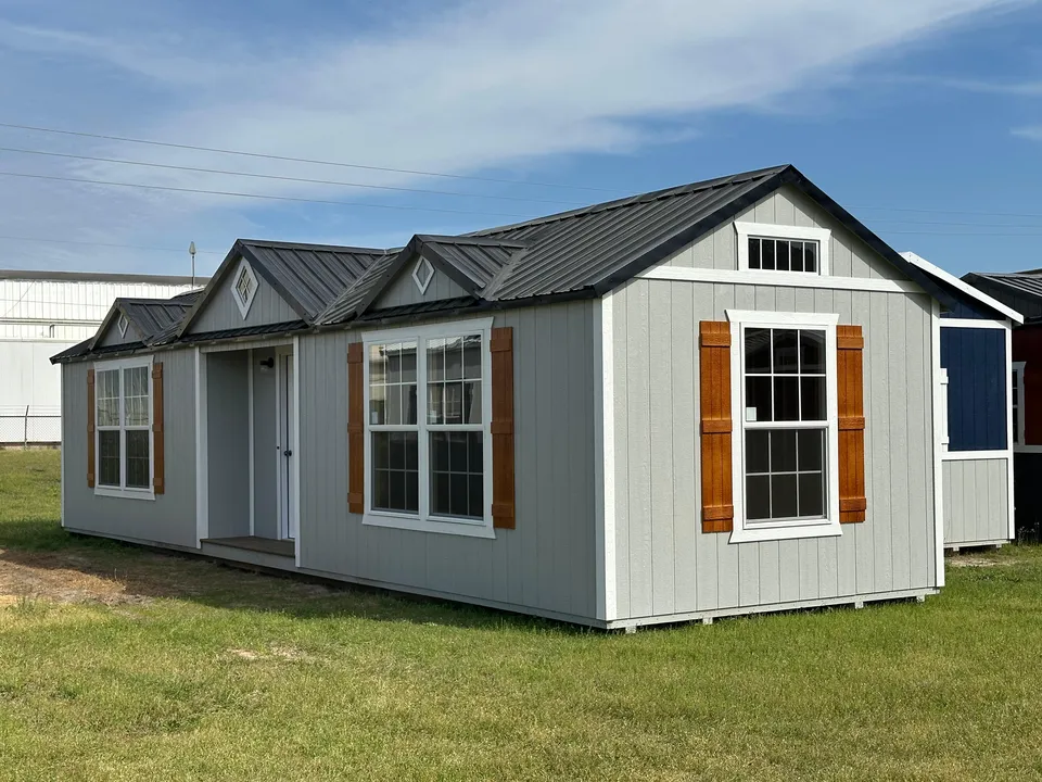 Gray cabin with gable dormers and cedar shutters