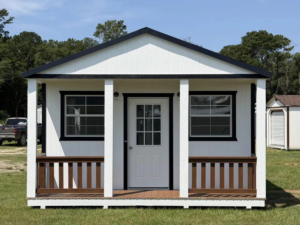 White porch cabin with black trim and a covered front porch