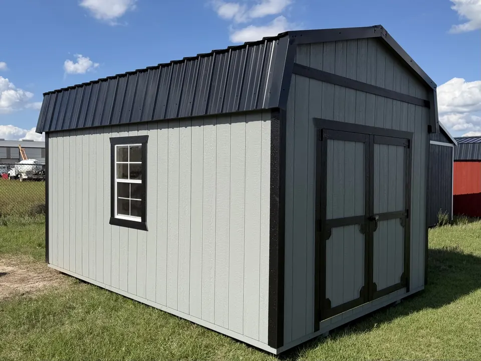 Light gray lofted barn with black trim, black metal gambrel roof and gable-end double doors