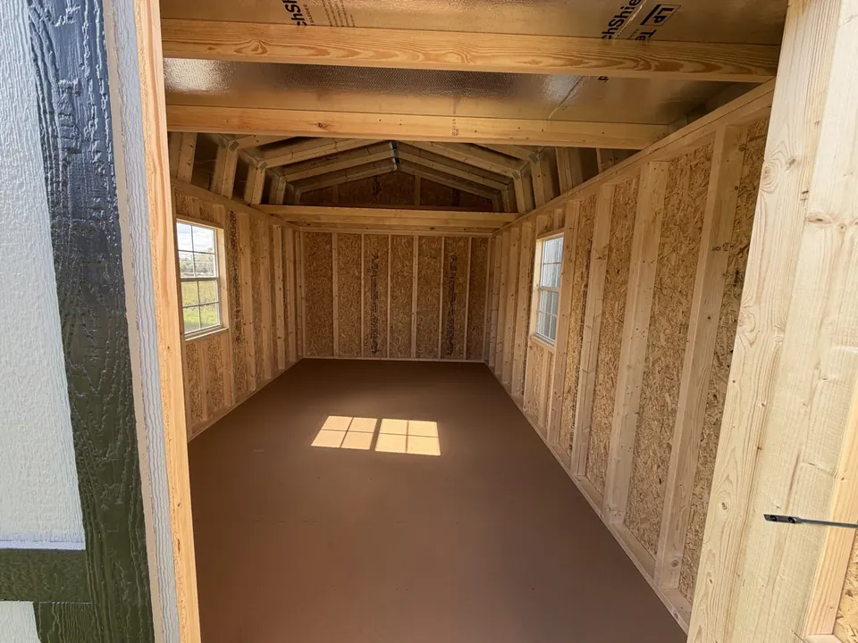 Inside a lofted barn showing wood framing and overhead loft decks at each end