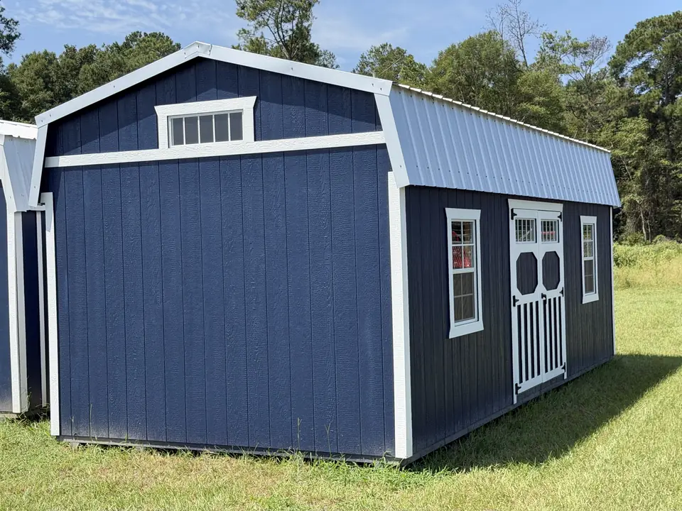 Navy lofted barn with white trim, transom double doors on the long side and a transom window in the gable