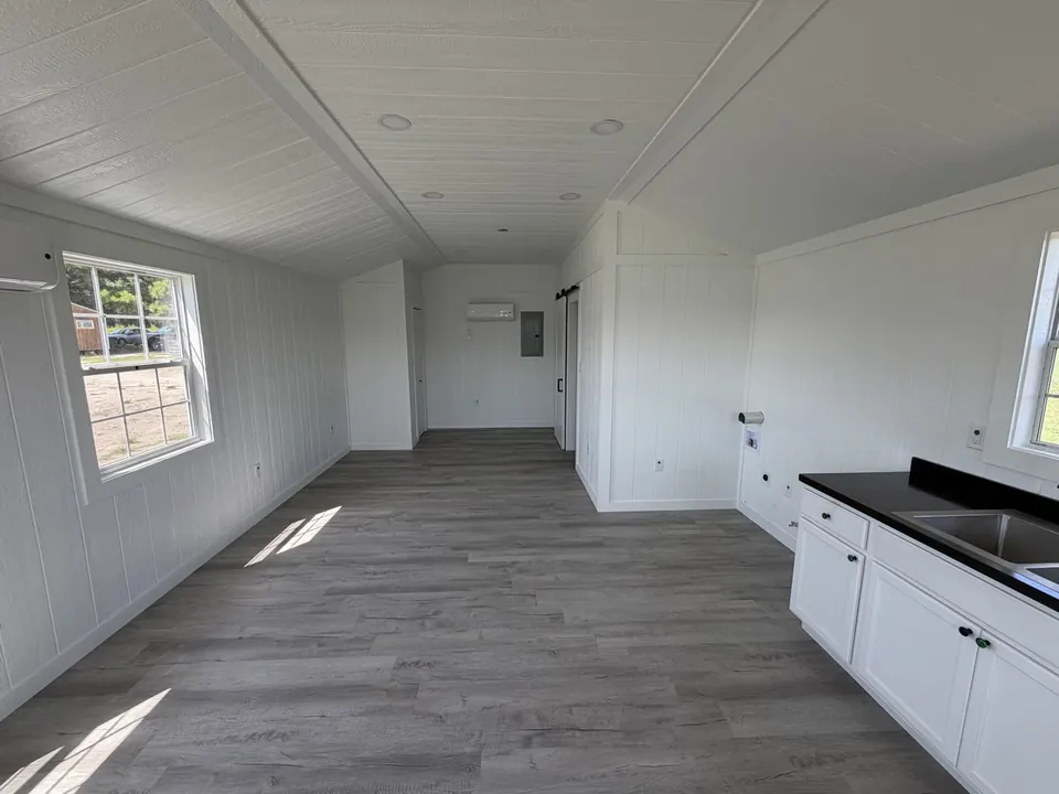 Finished tiny home interior with kitchenette and plank floors